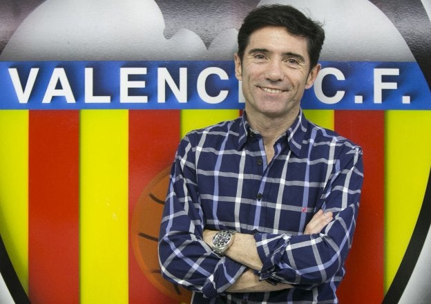 Marcelino posa junto al escudo del Valencia.