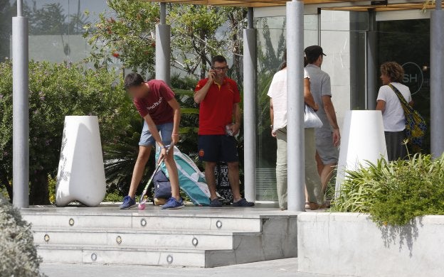 Un joven juega con un stick en la puerta del hotel junto al jefe de equipo de la Sub-21.