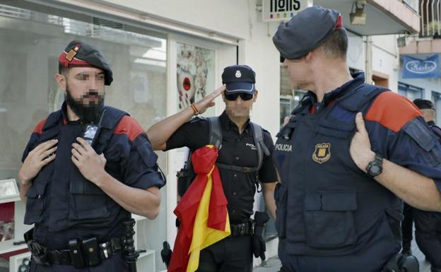 Un policía nacional, entre dos Mossos de Escuadra. /Efe