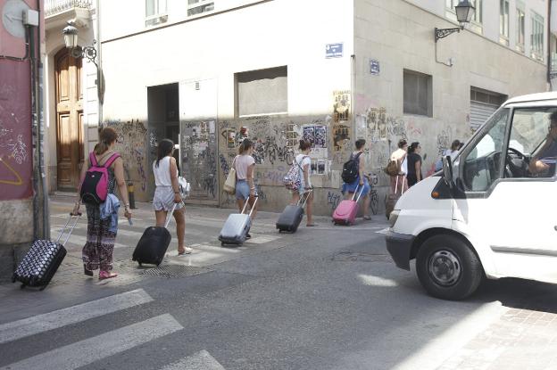 Un grupo de turistas, con sus maletas, en el centro de Valencia. / manuel molines