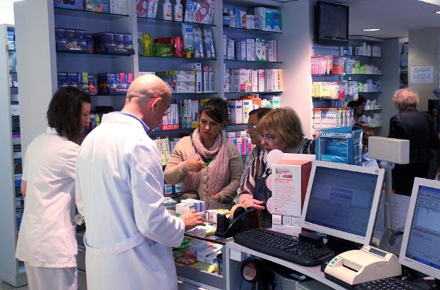Profesionales y pacientes, en una farmacia. / M. A.