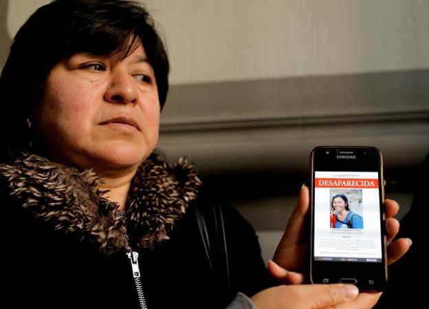 La madre de la joven desaparecida muestra una foto de su hija. / efe