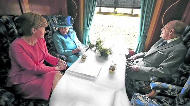 La reina Isabel, con su marido el duque de Edimburgo y la primera ministra escocesa, Nichola Sturgeon, el pasado martes en un tren. / REUTERS