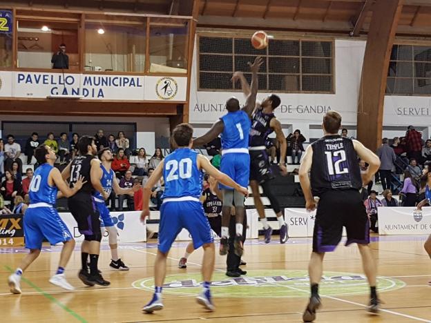 Un jugador del Hispagan y uno del Lucentum pugnan por el balón en el saque inicial. / bàsquet gandia