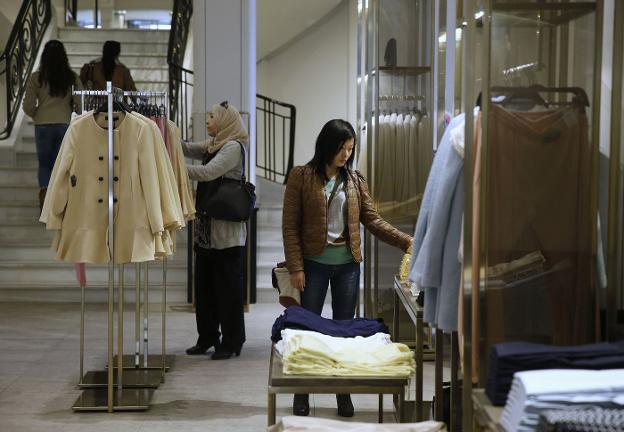Una mujer mira las prendas en una de las tiendas de Zara. / reuters