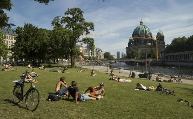 Berlineses toman en sol en un parque de la ciudad./
