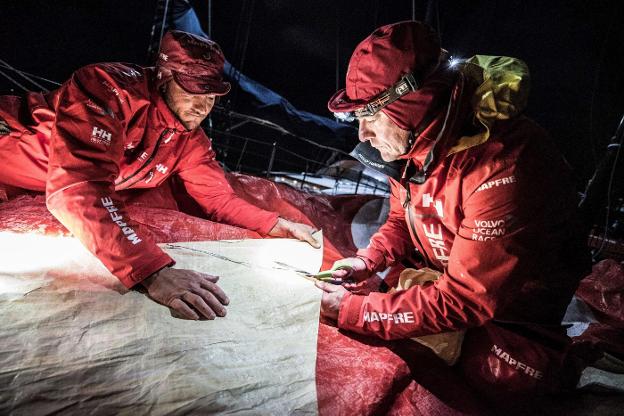 Blair Tuke (i) y Santi Pablos reparan la vela. / efe