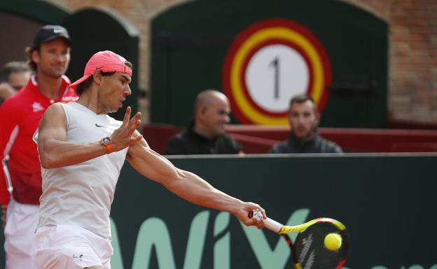 Nadal golpea ayer ante la mirada de Carlos Moyà./Jesús Signes