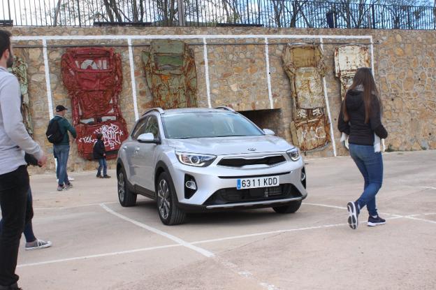 Visitantes junto a los coches que cuelgan junto a uno de los parkings./