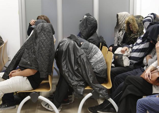 Algunos miembros de la banda se tapan la cara en un momento del juicio. / efe
