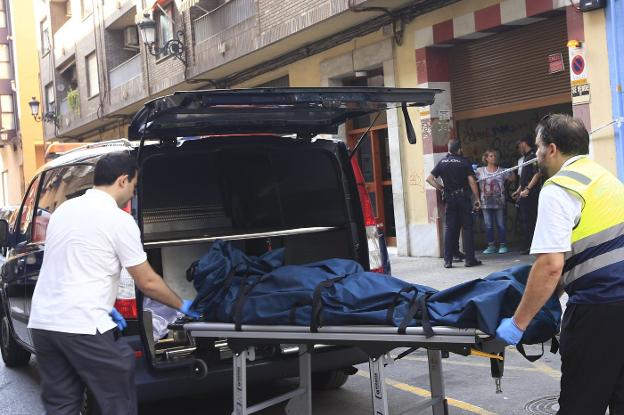 Empleados del retén fúnebre trasladan el cuerpo del hombre fallecido en el crimen de Patraix, del que está acusada su viuda. / Manuel molines