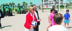 La consellera de Turismo, Belén Juste, jugando con los niños en presencia del alcalde, Ernesto Sanjuán, y con los terrenos del Manhattan al fondo. ::
JUAN PENADÉS/