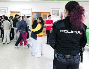 Un policía observa a un grupo de estudiantes dentro de un instituto. :: EFE/