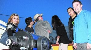 Unos jóvenes en la terraza de la 'Casa del Sol i la Lluna', con el telescopio. R. Martínez/