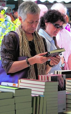 Dos mujeres ojean los libros de una caseta. :: JUAN JOSÉ MONZÓ/