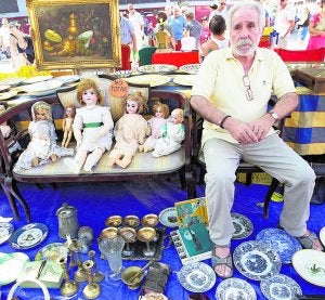 Espera. García posa con sus antigüedades y con muñecas que sabe que no venderá por su elevado valor. :: DAMIÁN TORRES/