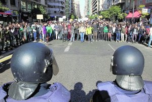 Un grupo de jóvenes frente a un cordón policial en la calle San Vicente Mártir durante los incidentes de febrero. :: JUANJO MONZÓ/