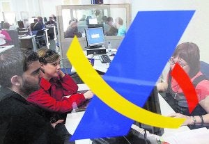 Unos contribuyentes, en una oficina de la Agencia Tributaria para presentar su declaración del IRPF. :: ALBERT OLIVÉ/EFE/
