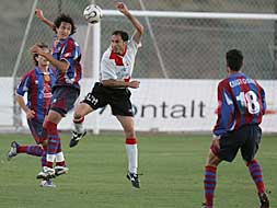 Un jugador del Levante B se disputa un balón aéreo con un rival./