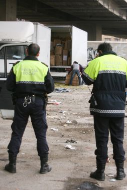 Dos policías vigilan los camiones cargados de artículos falsificados./