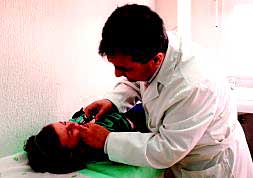 Un médico examina la garganta de una niña./