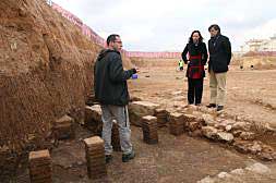 El arqueólogo muestra las termas romanas, junto al alcalde y la edil de Cultura./