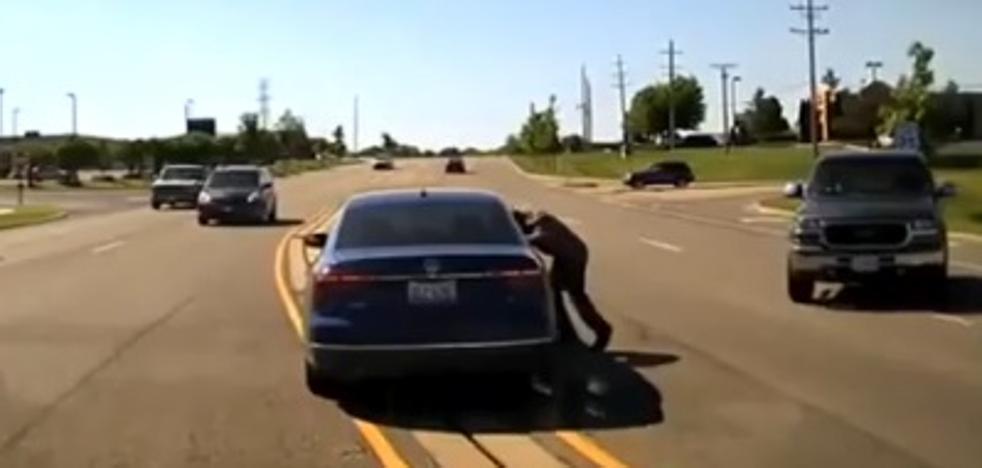Se mete por la ventana de un coche para salvar al conductor