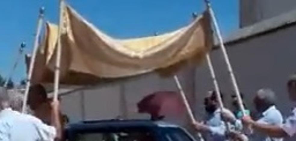 Un cura realiza la procesión del Corpus subido a un Mercedes bajo palio