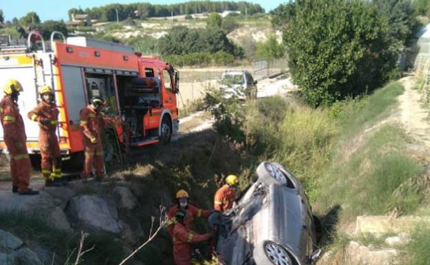 Los bomberos rescatan a dos heridos atrapados tras volcar un coche en Ontinyent