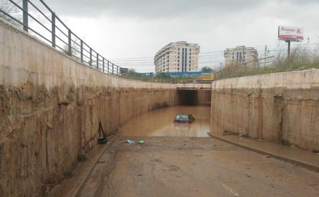 Dos guardias civiles rescatan a un conductor que estaba con el agua al cuello en un túnel en Alboraya