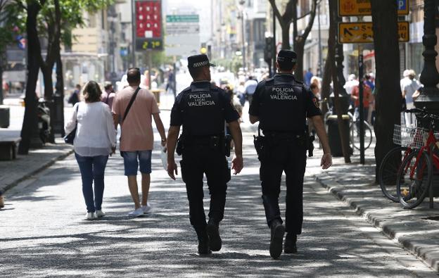 Una pareja de policías locales recorre la calle San Vicente. / Juan J. Monzó