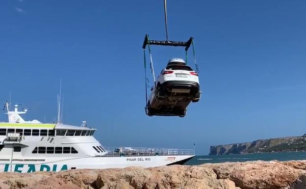 Una gran grúa saca desde tierra los coches del ferry encallado en Dénia