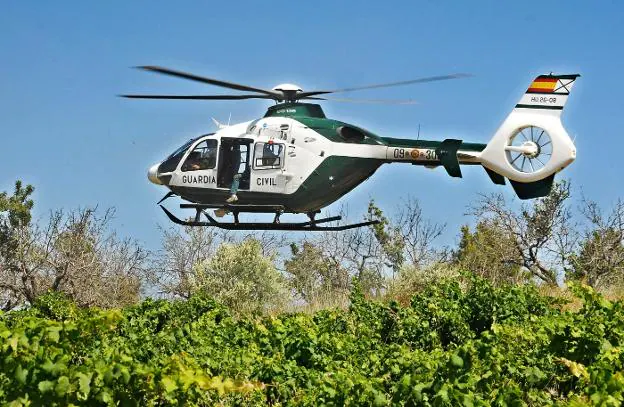 Un helicóptero de la Guardia Civil de Valencia sobrevuela un campo. josé iglesias/