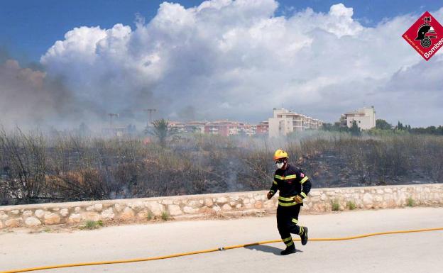 Los bomberos apagan un fuego en una parcela de matorral en Dénia