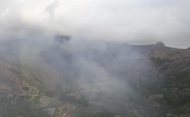 Los bomberos trabajan en la extinción de un incendio declarado anoche en Benimantell