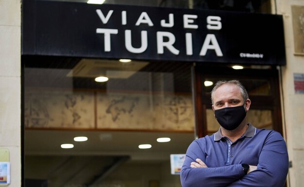 El empresario Martín Ochando junto a su agencia de viajes, que mantiene abierta en Valencia a pesar de las crisis. /Iván Arlandis