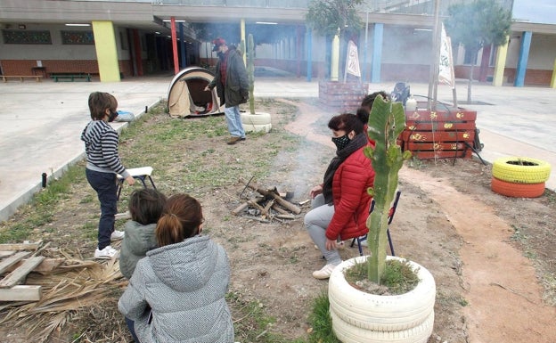 Los padres encienden una fogata para protegerse del frío en el colegio durante este puente. /efe/pep morell