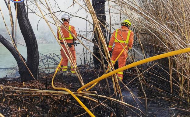 Los bomberos trabajan para extinguir un incendio en Requena, junto al Júcar y Fuentepodrida