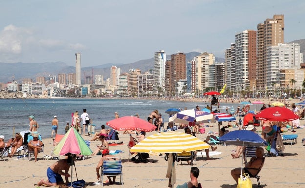 Decenas de personas disfrutan de un soleado día de playa en Benidorm./ Tino Calvo