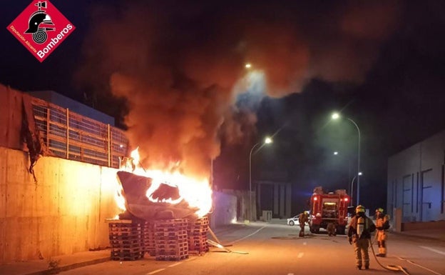 Arden un barco y varios palés en el polígono industrial de Benissa