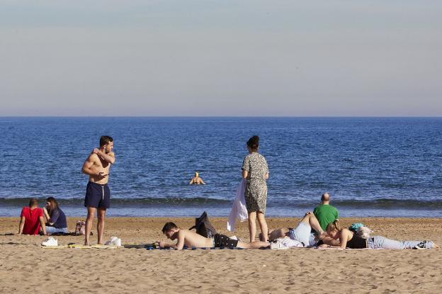 Algunos de los bañistas que ayer desafiaron el calendario e incluso se fueron a bañar en la playa de la Malvarrosa.  Ivan Arlandis /
