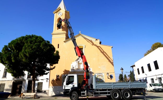 Una grúa baja las tres campanas de la iglesia de Benetússer para su rehabilitación tras 60 años repicando