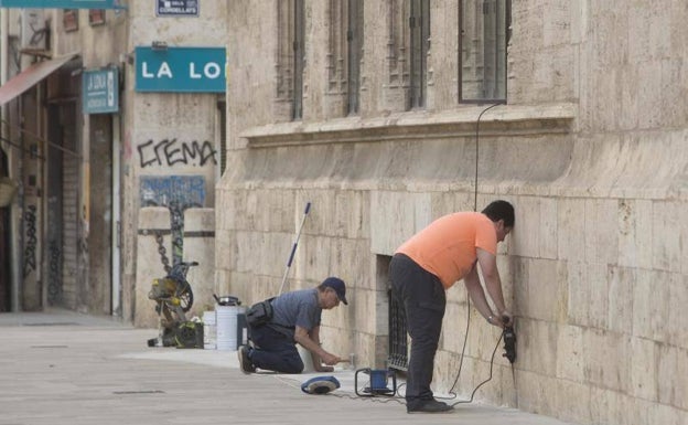 Taladran el suelo recién instalado junto a la Lonja para poner tratamiento contra termitas