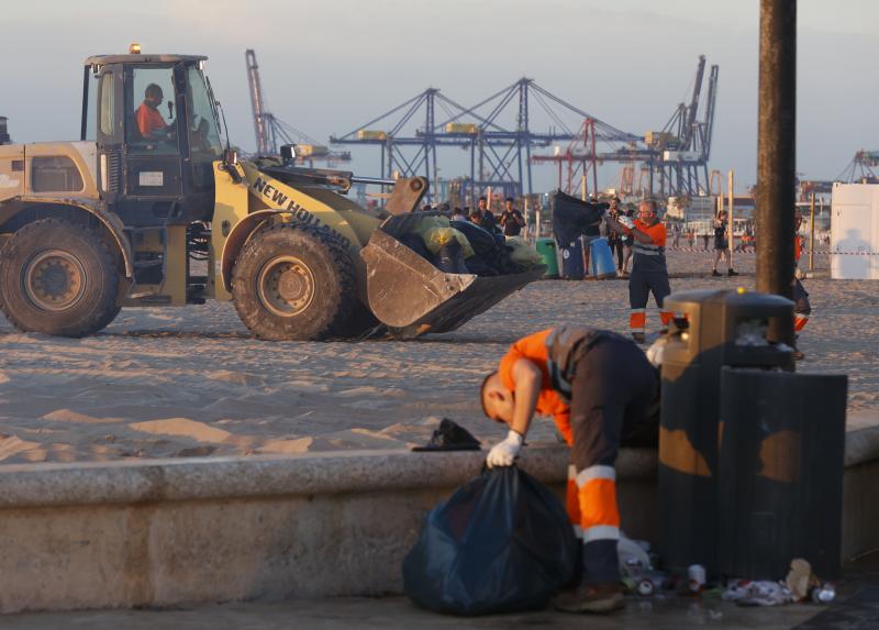 Labores de limpieza al amanecer tras el macrobotellón de la noche de San Juan en Valencia