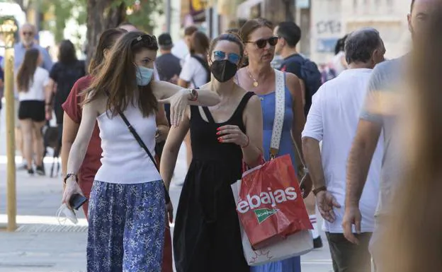 Personas con y sin mascarillas en las calles de Valencia. 