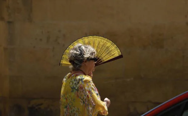 Imagen de archivo de una mujer tapándose con un abanico