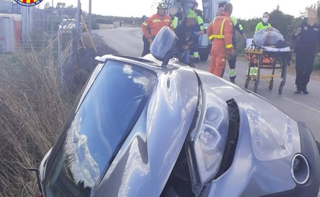 Los bomberos rescatan a dos personas del interior de un vehículo accidentado en Puçol