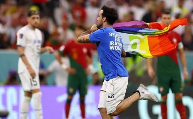 Un espontáneo salta al campo con una bandera arcoíris durante el Portugal-Uruguay