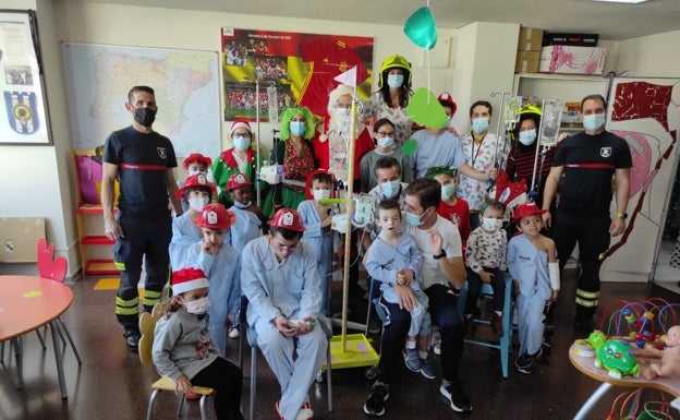 Los bomberos solidarios llevan magia y alegría navideña a la planta de oncología del General de Alicante