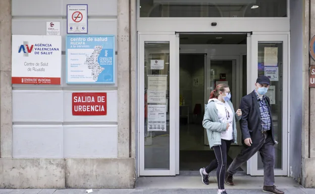 Dos usuarios salen de un centro de salud. 